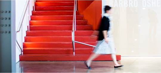 photo of woman walking past some stairs